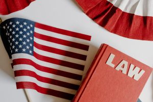 Photo by Tara Winstead: https://www.pexels.com/photo/american-flag-beside-a-law-book-on-white-background-8850743/