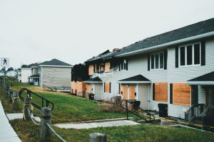 Photo by Jonathan Cooper: https://www.pexels.com/photo/a-row-of-houses-with-boarded-windows-and-boarded-doors-27639887/