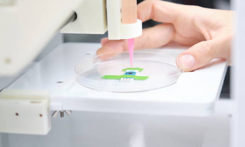 Researcher getting 3D bioprinter ready to 3D print cells onto an electrode. Biomaterials, tissue engineering concepts.