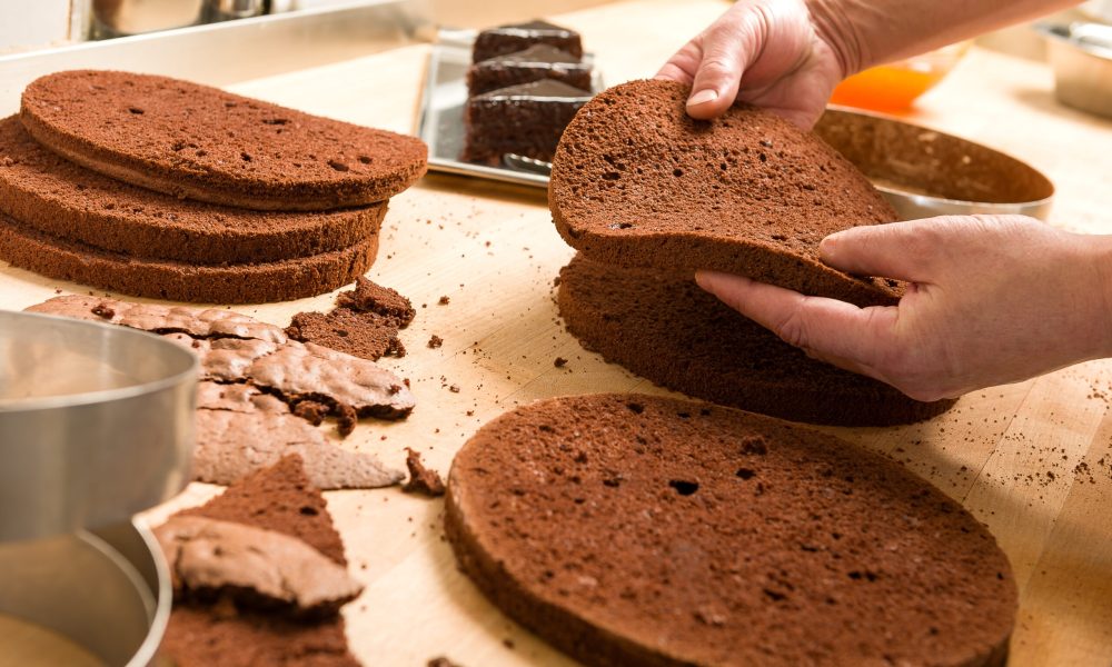 Chef cutting chocolate cake layers and stacking them