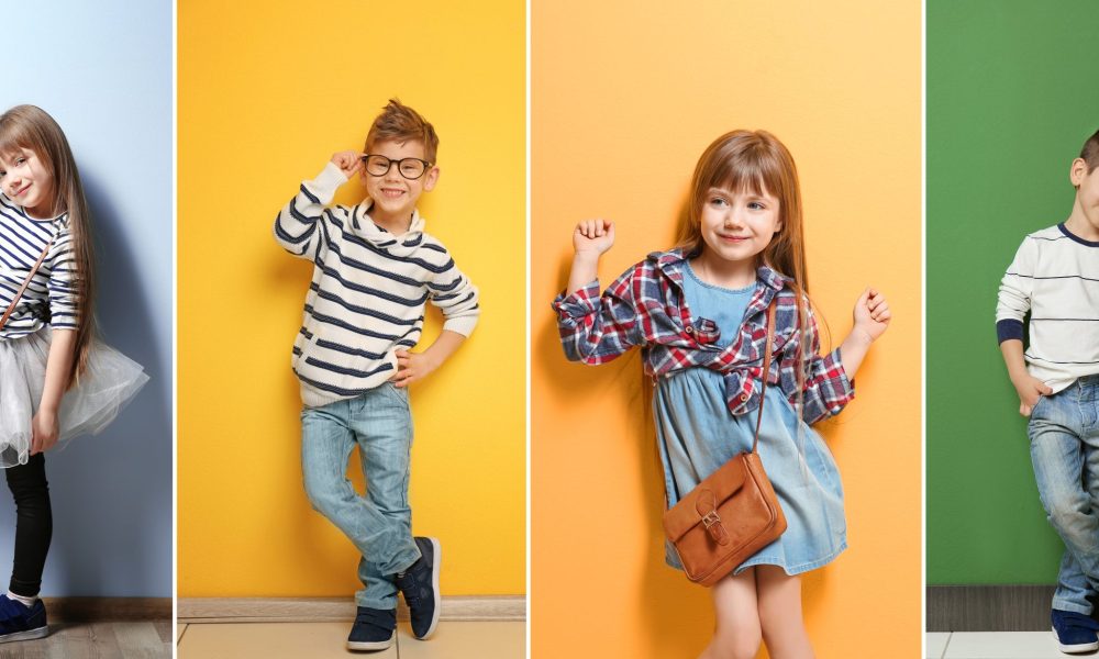 Cute stylish boy near color wall