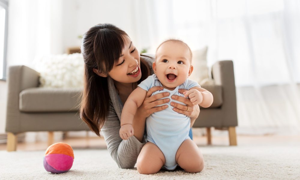 family and motherhood concept - happy smiling young asian mother with little baby at home