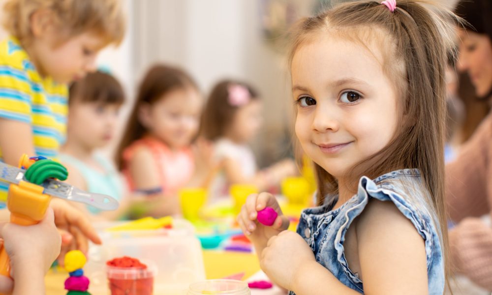 happy kids doing arts and crafts in daycare centre