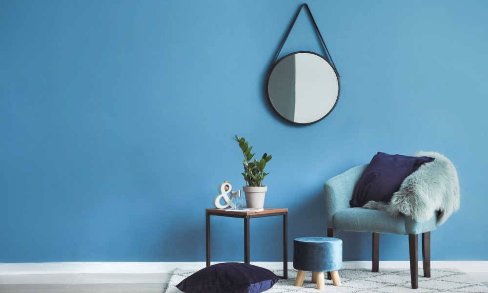 Beautiful interior with comfortable armchair, table and mirror