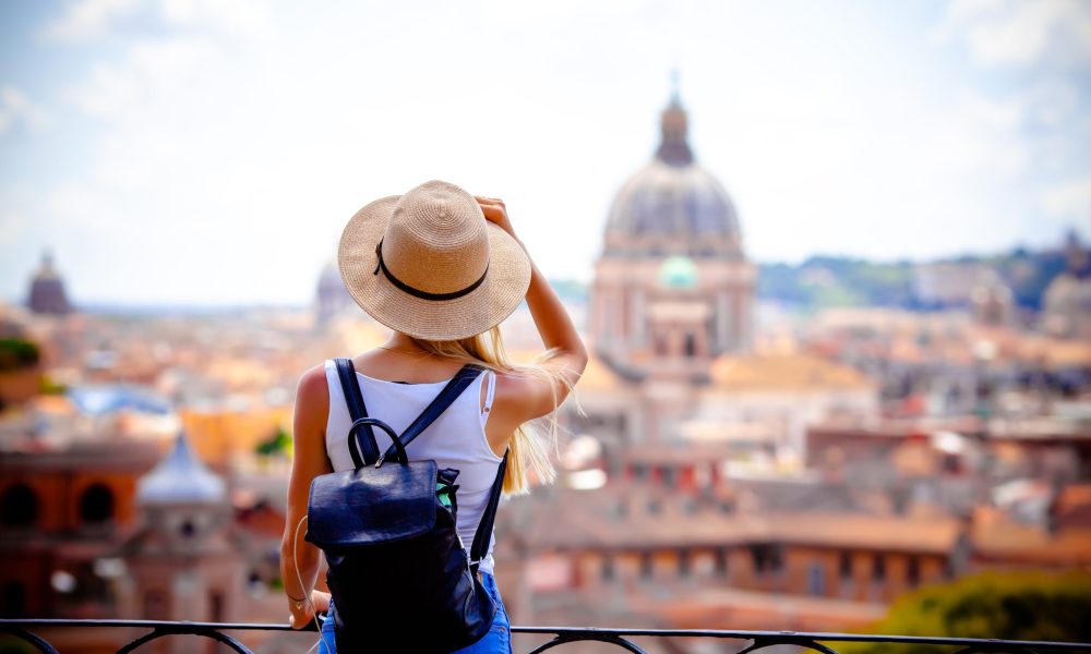 Rome Europe Italia travel summer tourism holiday vacation background -young smiling girl with mobile phone camera and map in hand standing on the hill looking on the cathedral Vatican