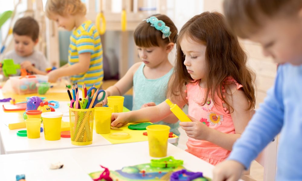 Art and craft activity in kindergarten. Preschool kids hands working in day care center. Group of children engaged in handcrafts