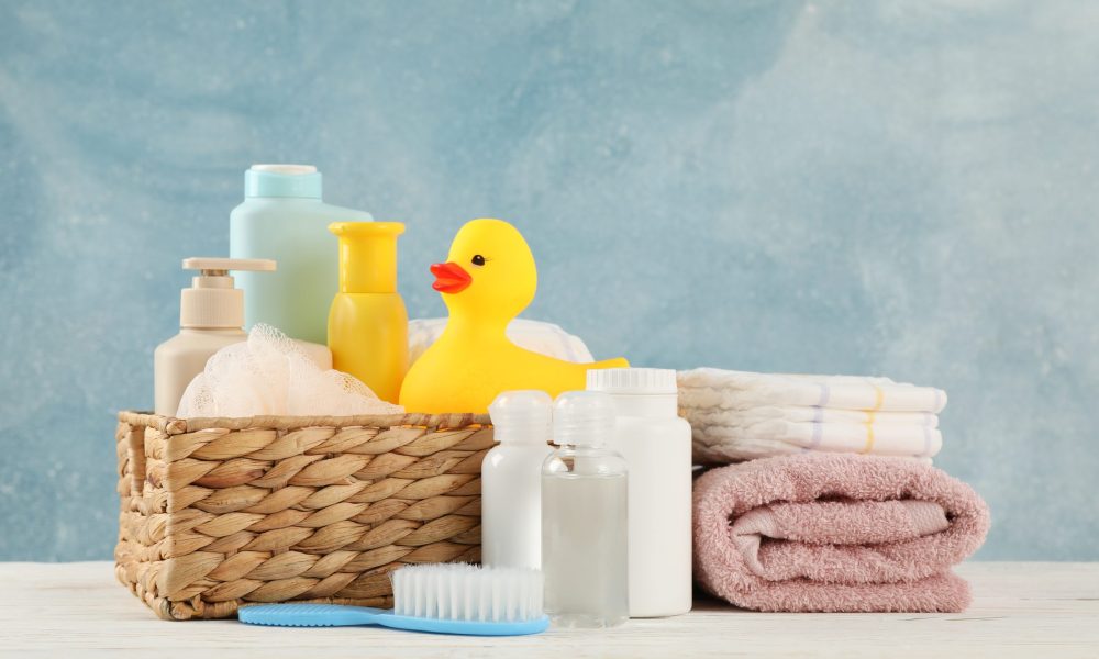 Baby hygiene accessories on wooden table against blue background