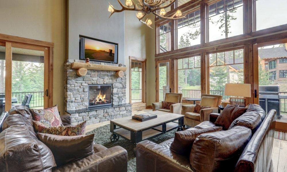 Amazing grand new luxury home with soft natural wall color and light hardwood floor, two story tall living room with sky bridge and leather furniture.
