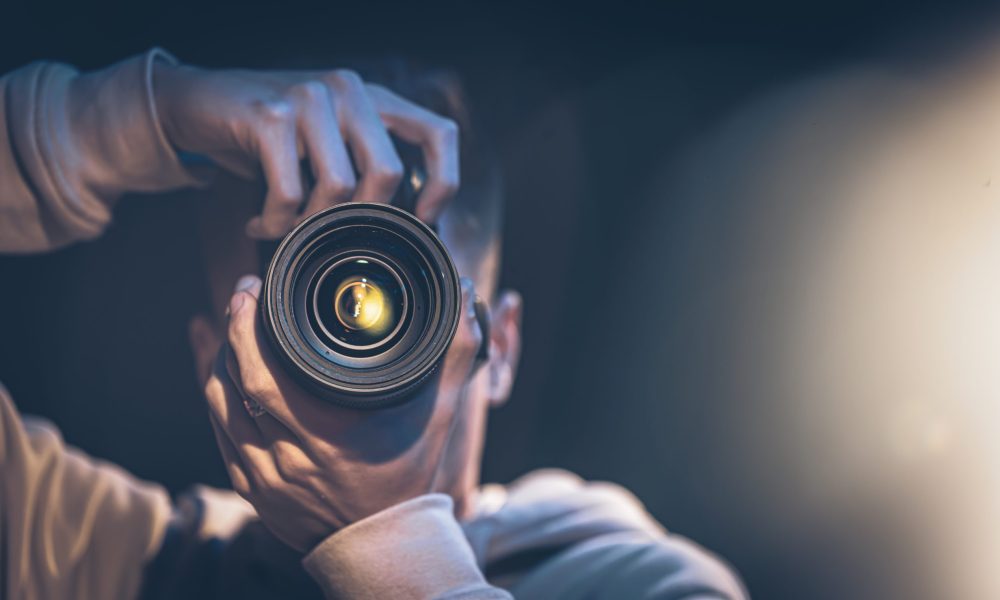 A male photographer takes pictures in the dark, a professional photographer takes pictures with a camera.