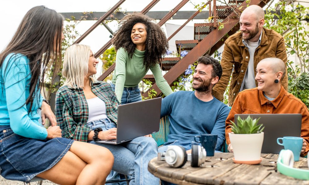Digital native group of friends sharing content and ideas in team work meeting,  tech life style concept with guys and girls having fun, telecommuting an remote work place concepts, young creative