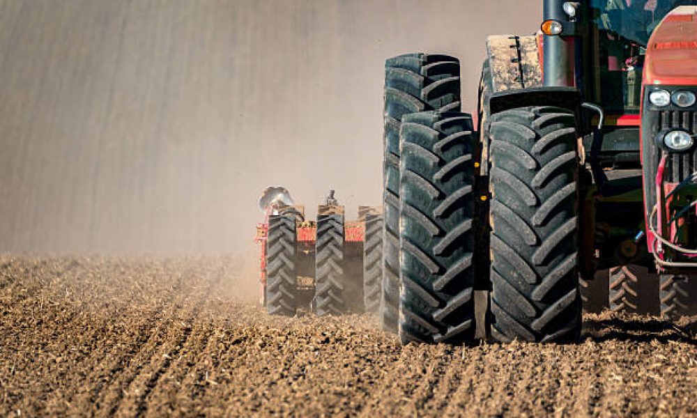 The tractor working on the brown field