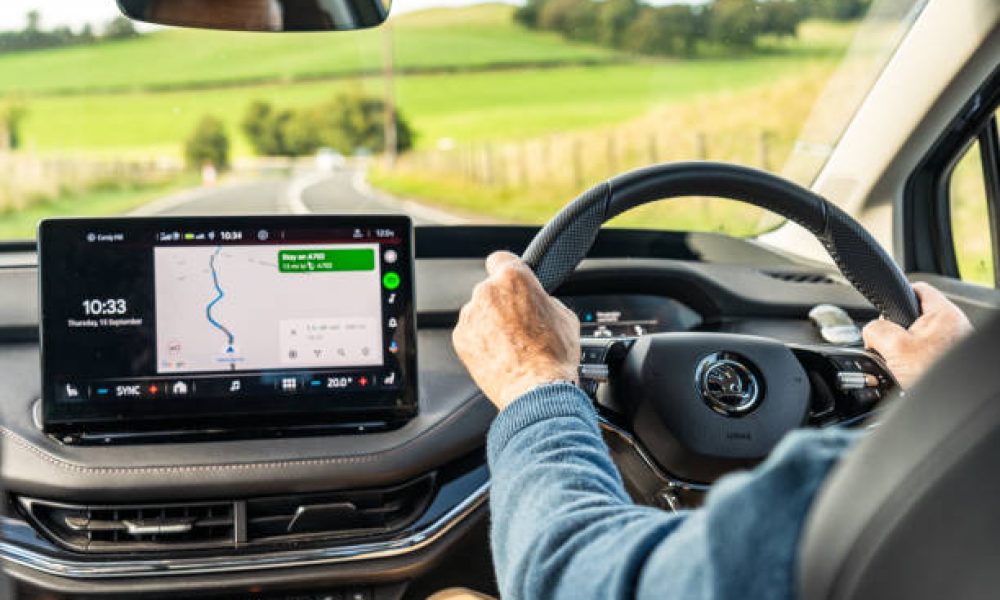 South Lanarkshire, Scotland - A man driving a Skoda Enyaq on a winding section of the A702, following a route planned on Google Maps using Android Auto.