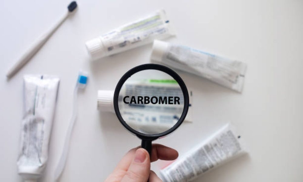 Checking the composition of toothpaste with a magnifying glass against the background of many tubes. Dangerous toothpaste ingredient carbomer.