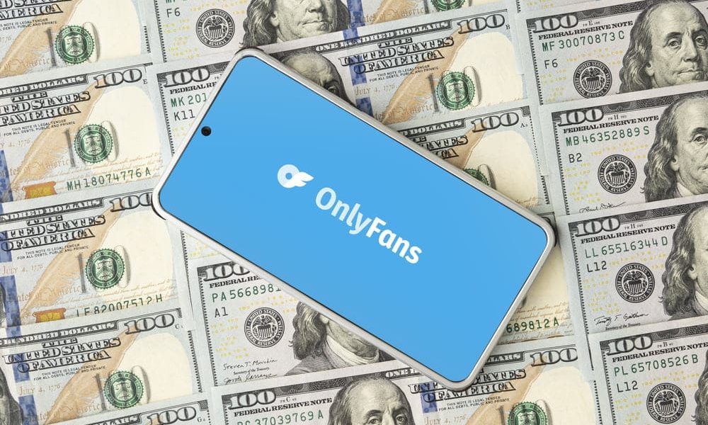Onlyfans logo on smartphone screen and dollar bills. OnlyFans is content subscription service.