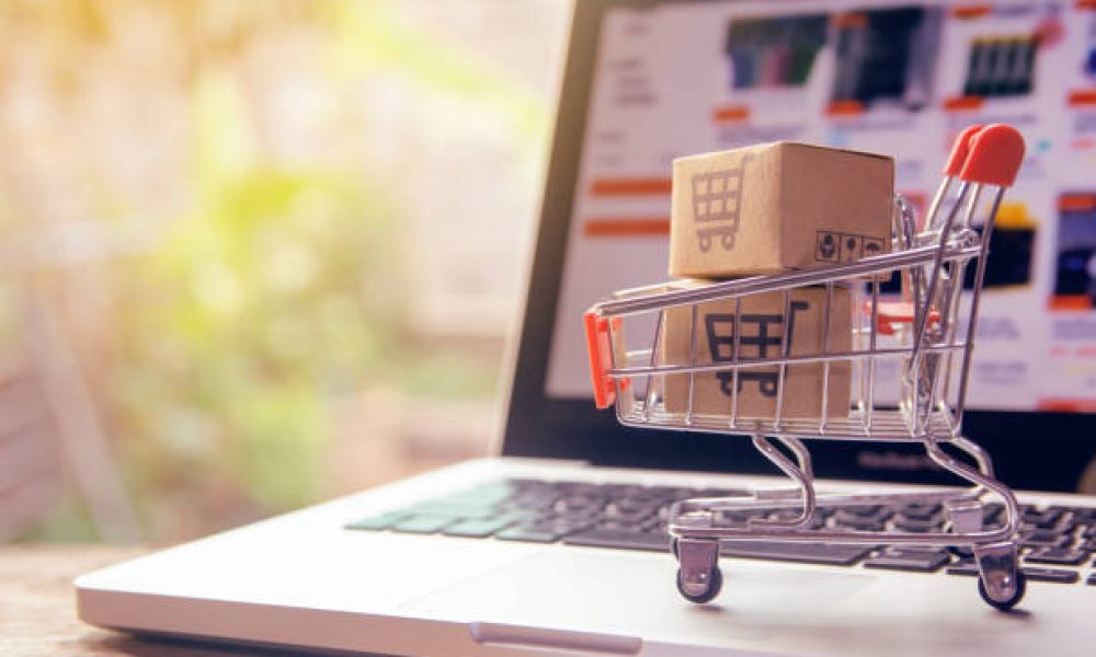 Shopping online concept - Parcel or Paper cartons with a shopping cart logo in a trolley on a laptop keyboard. Shopping service on The online web. offers home delivery.