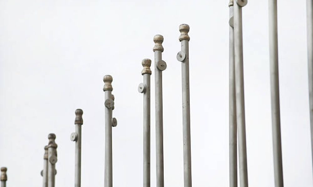 Multiple flag poles in a row with no flags