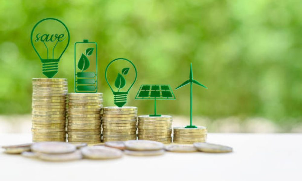 Alternative or renewable energy financing program, financial concept : Green eco-friendly or sustainable energy symbols atop five coin stacks e.g a light bulb, a rechargeable battery, solar cell panel