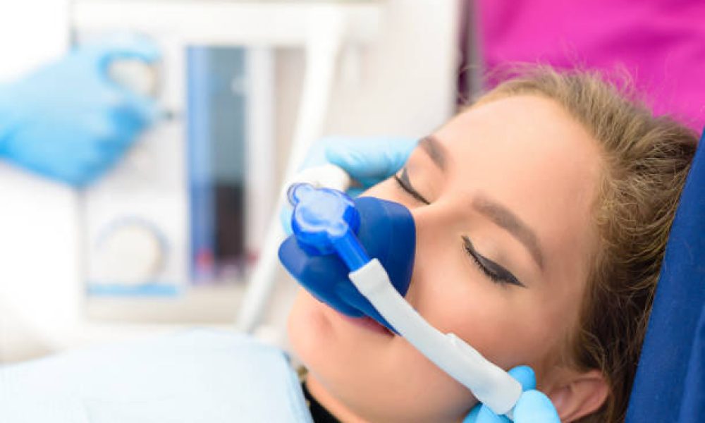 Beautiful getting woman inhalation sedation at dental clinic