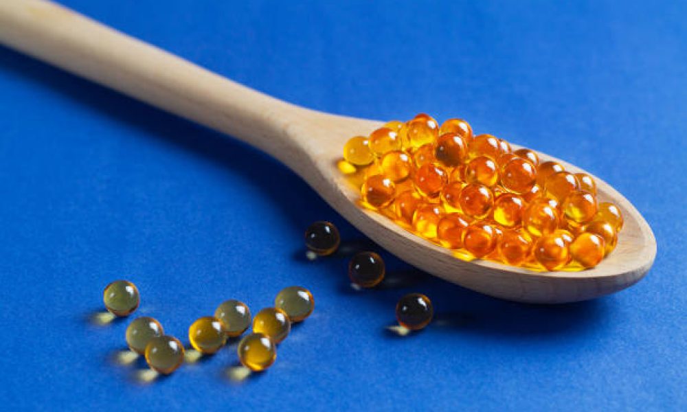 Omega 3 capsules on the blue background. Fish oil in pills. Healthy vitamins and treatment. Biologically active additives. copy space.