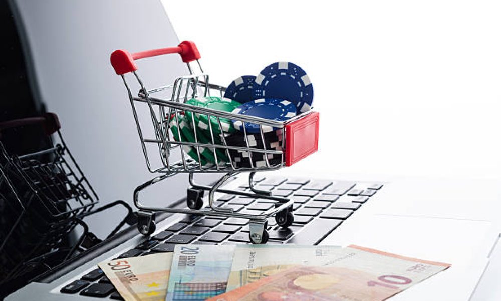 European currency and gambling chips on laptop keyboard.