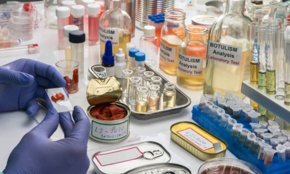 Experienced laboratory scientist analyzes red peppers from a canned food can to analyze botulism infection in sick people, conceptual image