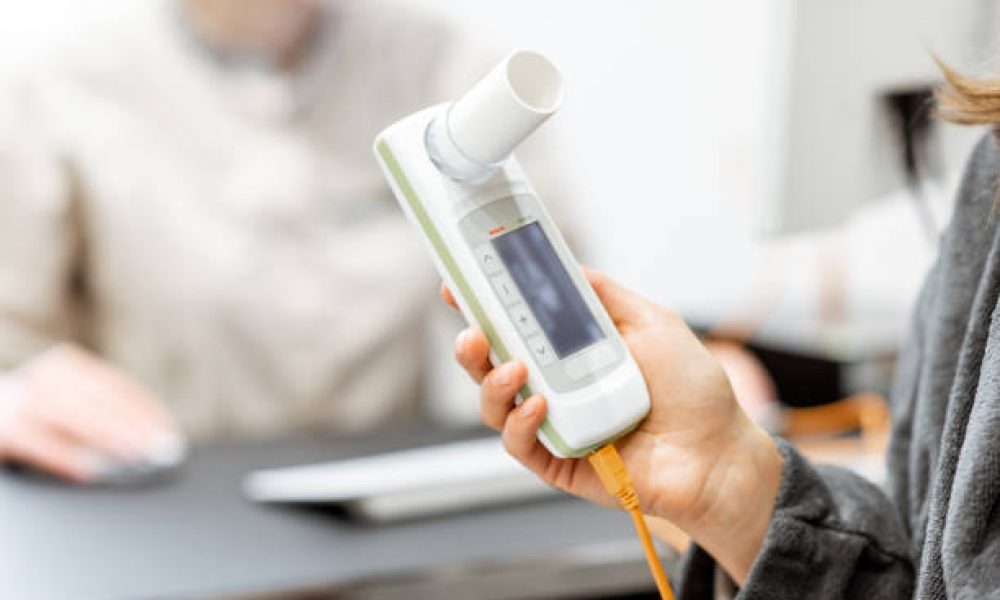 Patient holding spirometer, medical instrument for measuring breathing movemnts, close-up