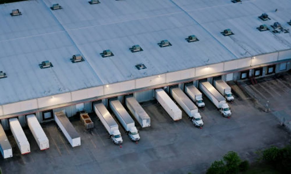Aerial shot of large semi-trucks parked in a warehouse in Houston, Texas in the evening.