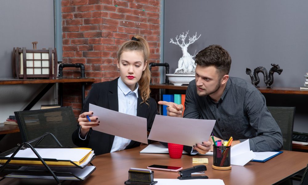 Two lawyers in an office reviewing documents together, discussing strategies for handling complex international legal cases.