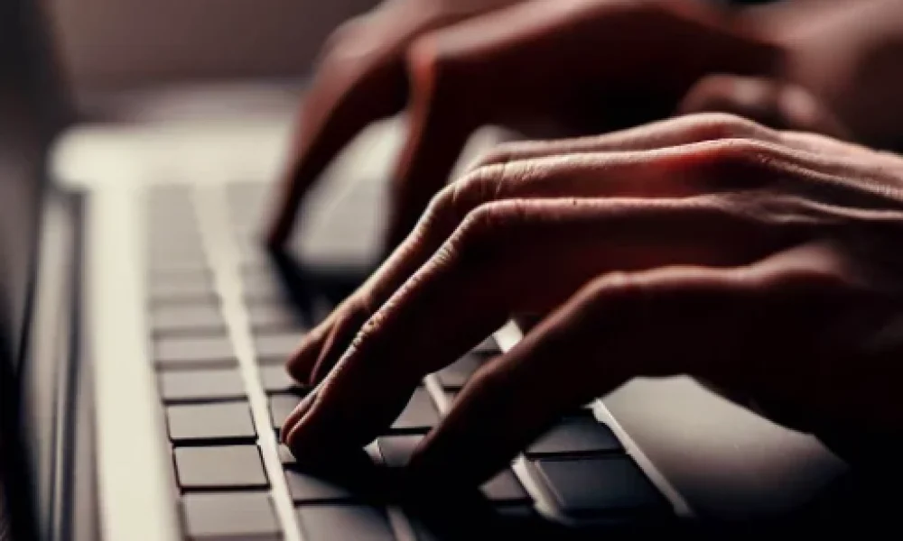 Hands at the keyboard of a laptop about to type