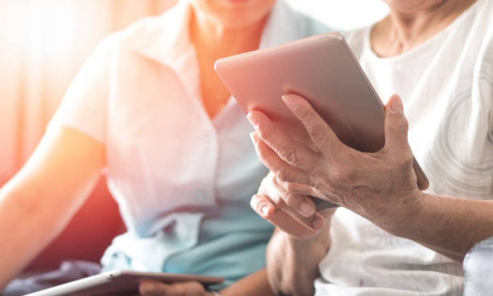 Happy elderly twin senior people society lifestyle with technology concept. Ageing Asia women using tablet  and smartphone share social media together in wellbeing county home.