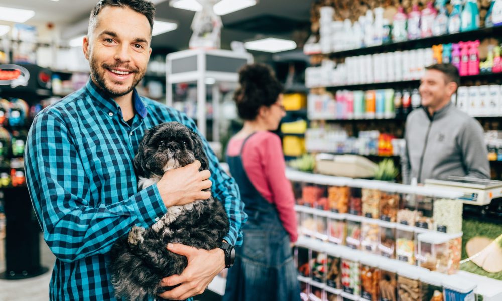Customers buying accessories and food for their pet in pet shop.
