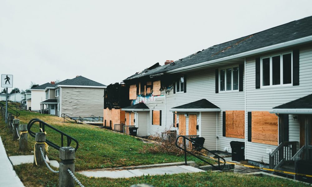 Photo by Jonathan Cooper: https://www.pexels.com/photo/a-row-of-houses-with-boarded-windows-and-boarded-doors-27639887/