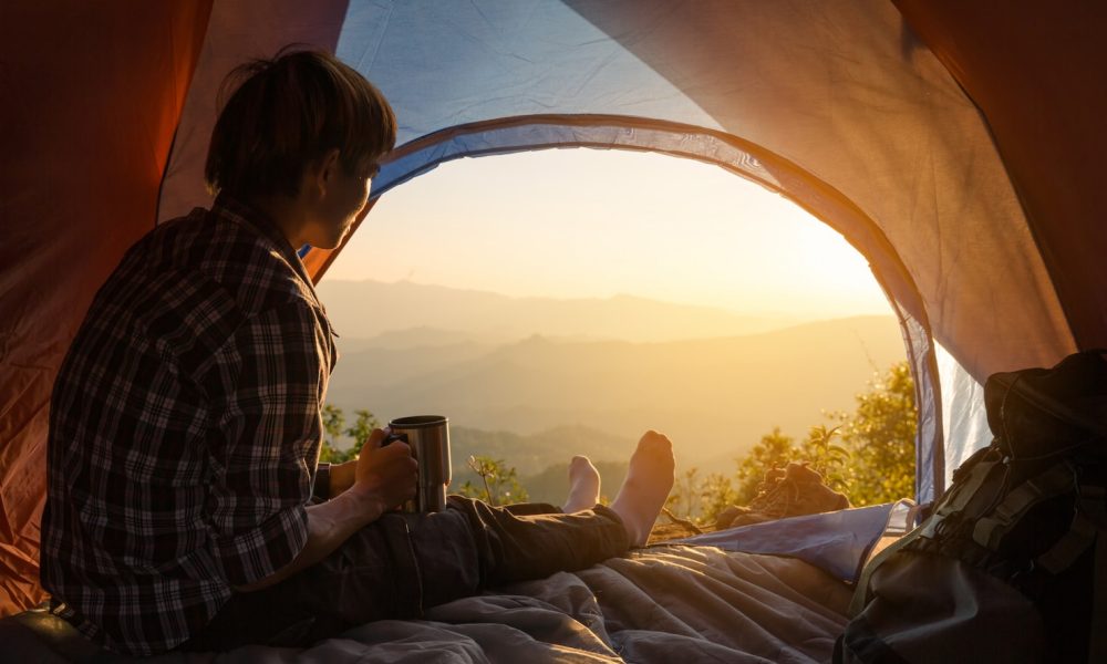 young-man-sitting-tent-with-holding-coffee-cup_1150-9136[1]